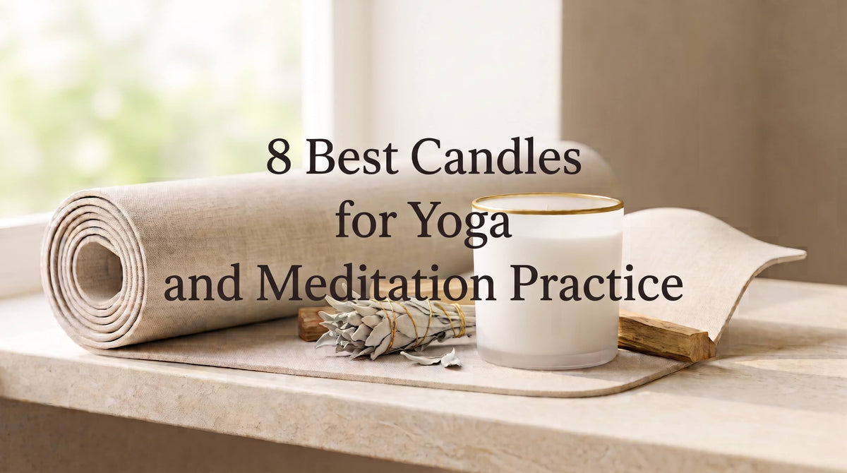 A white candle in a gold-rimmed glass jar positioned on a rolled-up yoga mat alongside a bundle of dried white sage and a Palo Santo stick.